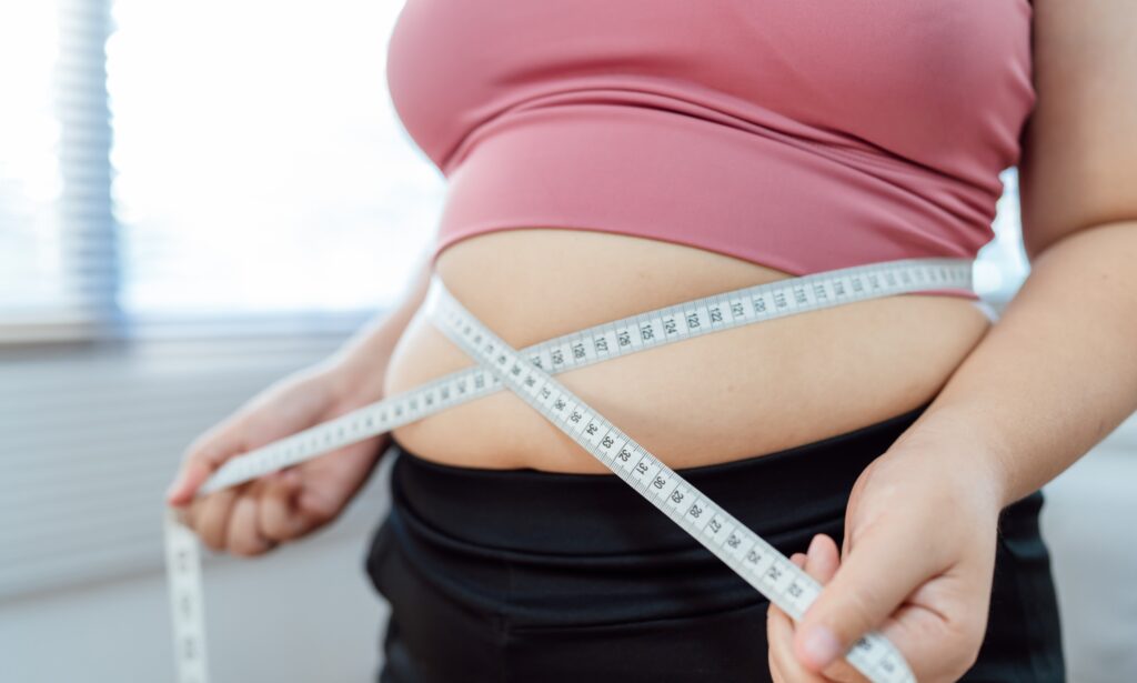 woman measuring waist with tape measure